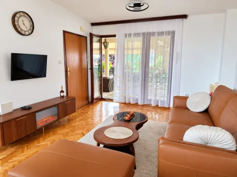 Living room with leather sofa set, TV, and access to the terrace. - image 4