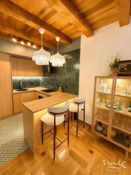 Modern kitchen with wooden elements, a breakfast bar and hanging chandeliers. - image 3