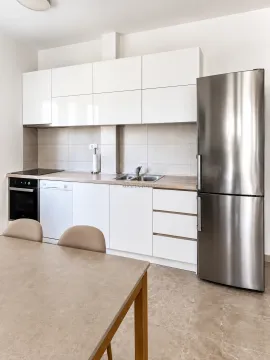 Moderna bijela kuhinja sa ugrađenim aparatima i trpezarijskim stolom. - image 4