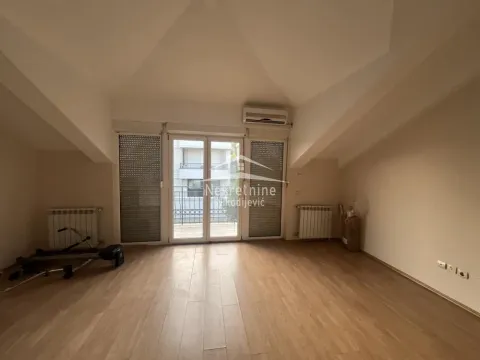 Empty room with wooden flooring, air conditioning unit, and balcony doors. - image 9