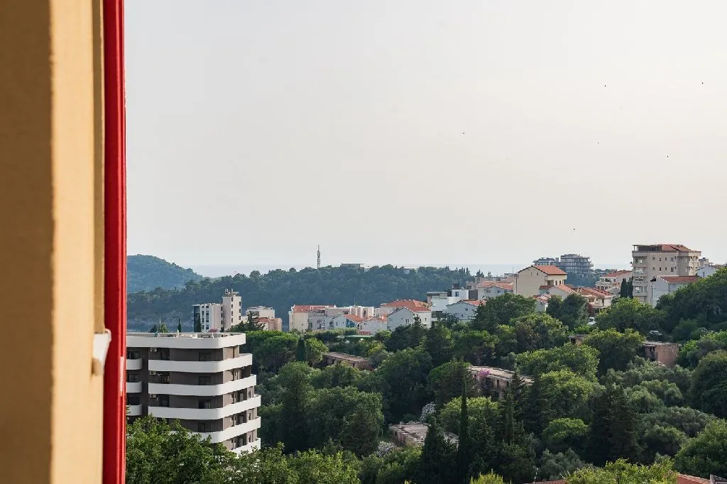 Pogled na gradsko naselje i zelenilo iz nekretnine.