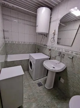 Bathroom equipped with a bathtub, washbasin, washing machine and water heater. - image 4