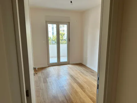 Prazna soba sa drvenim podom i balkonskim vratima. - image 11