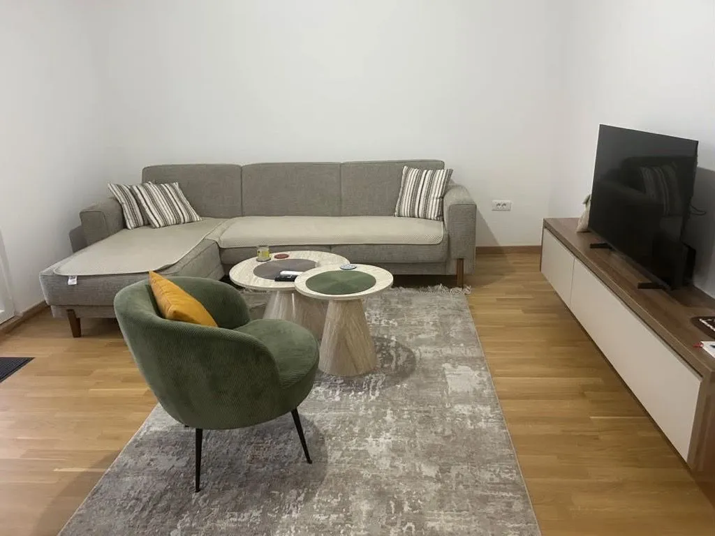 Living room with a sofa, armchair, and television.