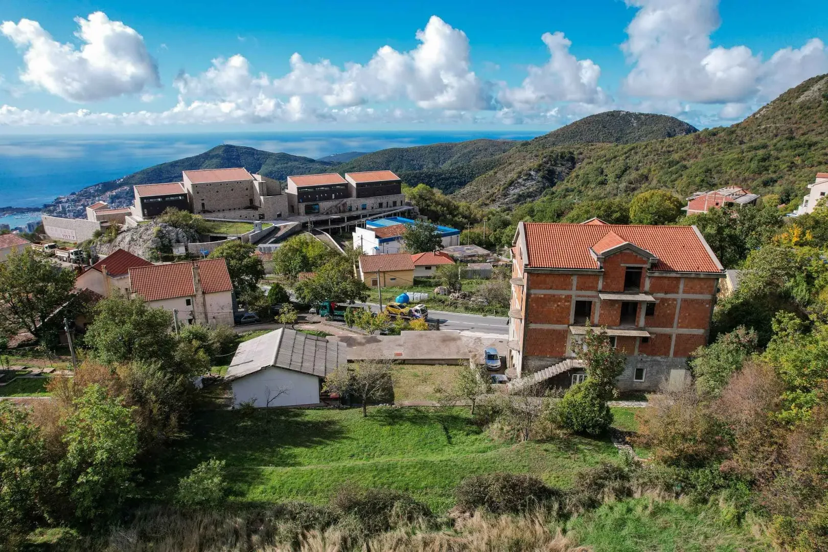Pogled iz vazduha na objekte u izgradnji i okolni pejzaž.