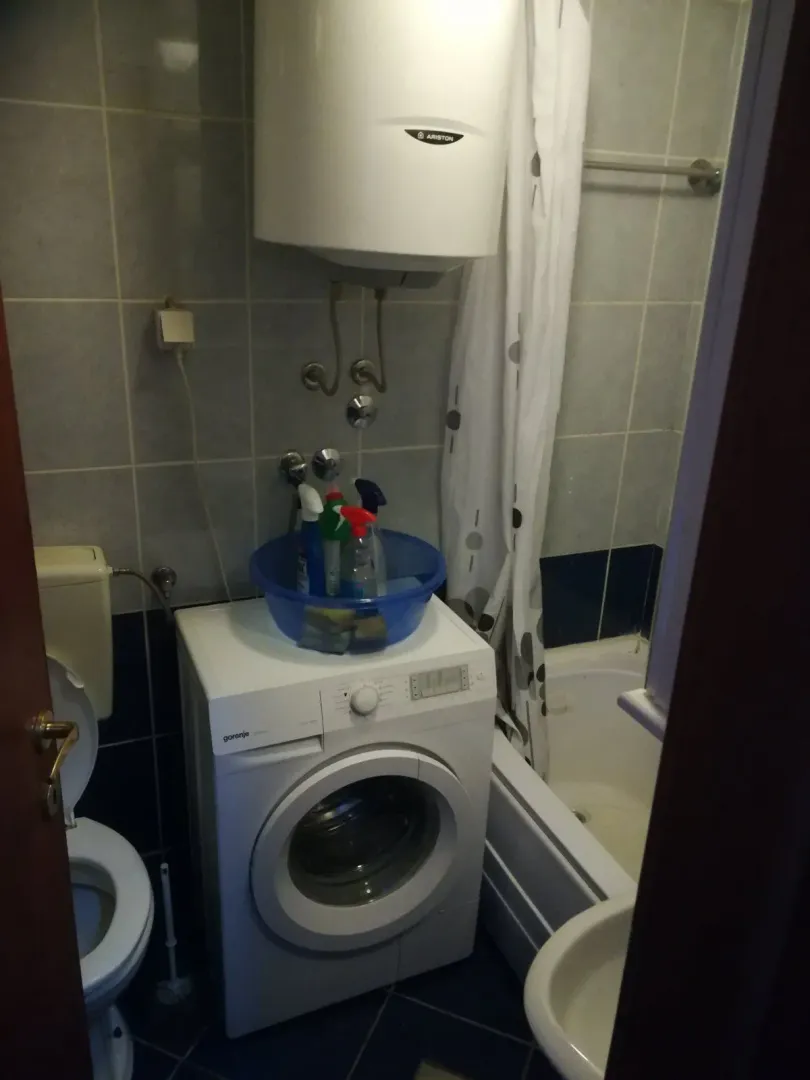 Malo kupatilo sa veš mašinom, bojlerom i kadom.
