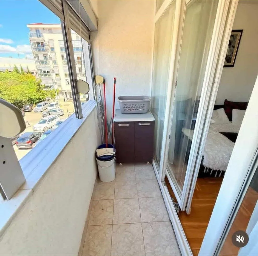 Enclosed balcony with a view of the street and parking lot.