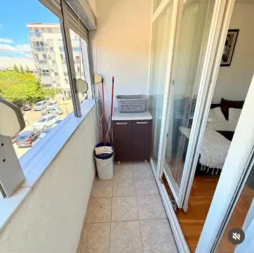 Enclosed balcony with a view of the street and parking lot. - image 8