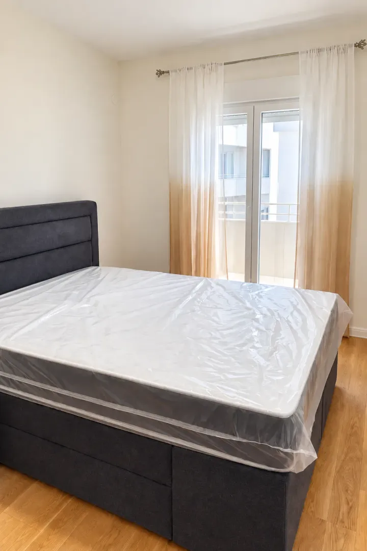 Bedroom with a double bed and a window with curtains.