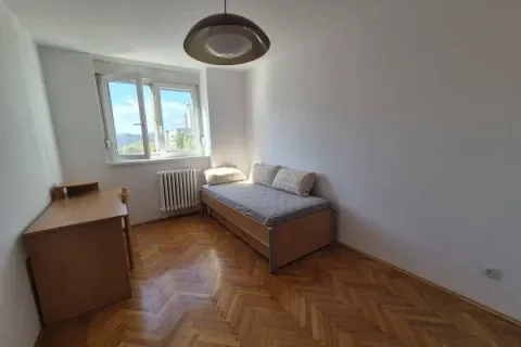 Small bedroom with a single bed, a desk, and parquet flooring. - image 5