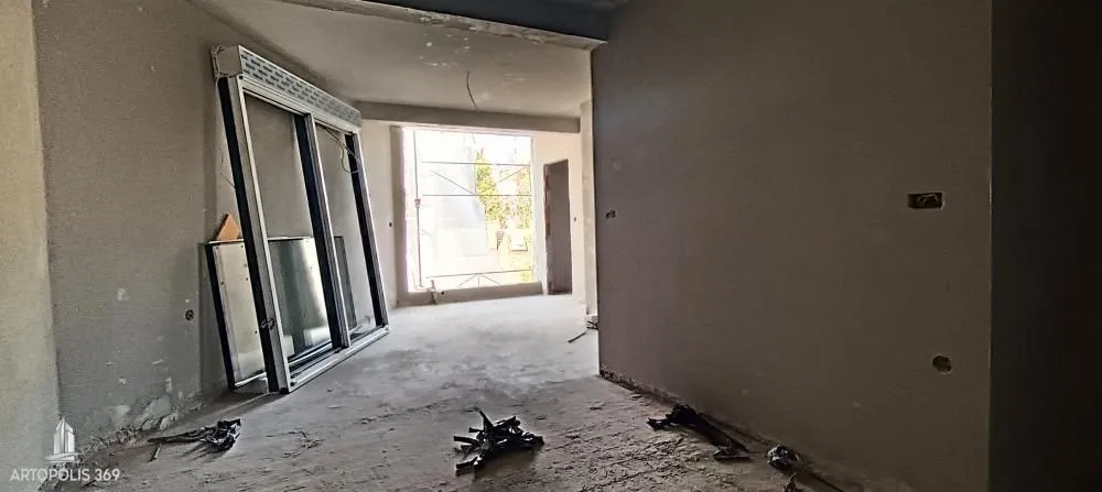 Neuređen enterijer u izgradnji sa betonskim podom i zidovima.