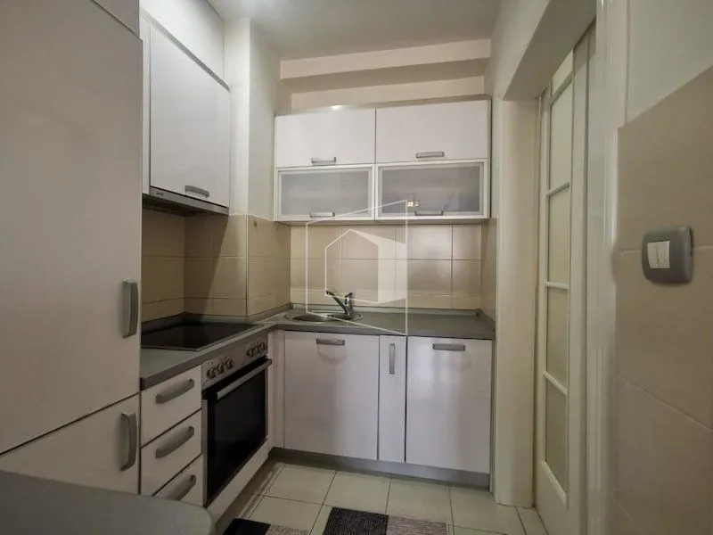 Small kitchen with white cabinets and built-in appliances.