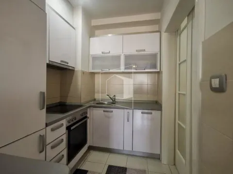 Small kitchen with white cabinets and built-in appliances. - image 4