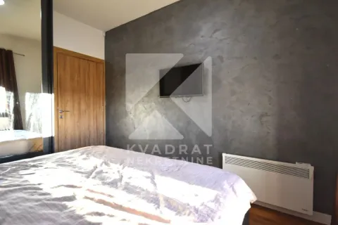 Bedroom with a double bed, grey wall, and a television. - image 13