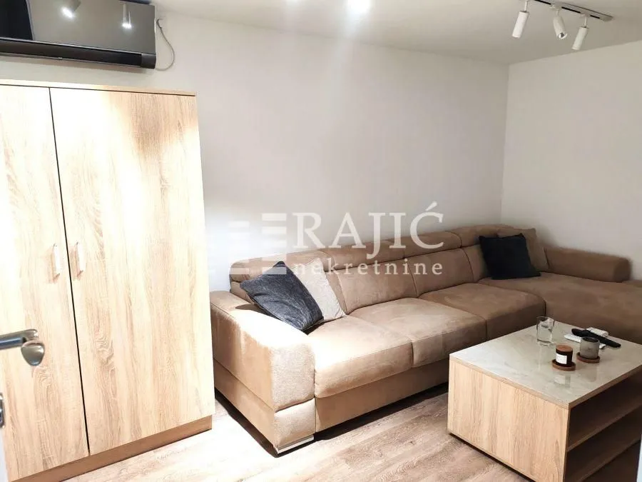 Living room with a sectional sofa, wardrobe, and coffee table.