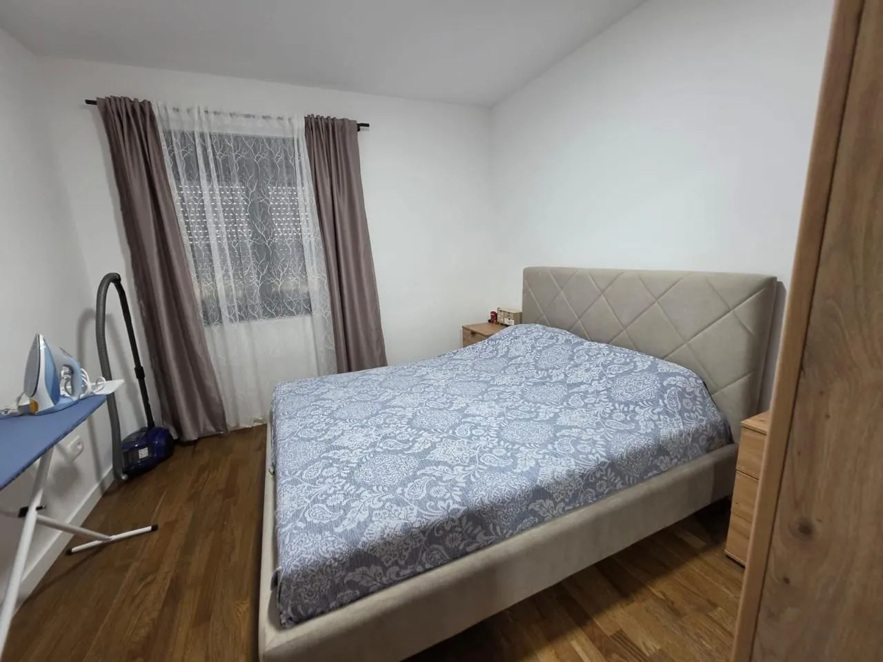 Namještena spavaća soba sa bračnim krevetom.
