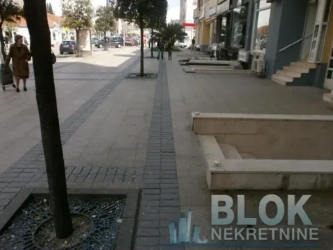 View of the street and sidewalk in front of the building with commercial spaces. - image 7