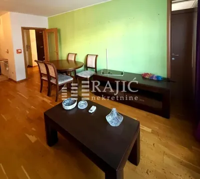 Living room with a dining area and a green accent wall. - image 2