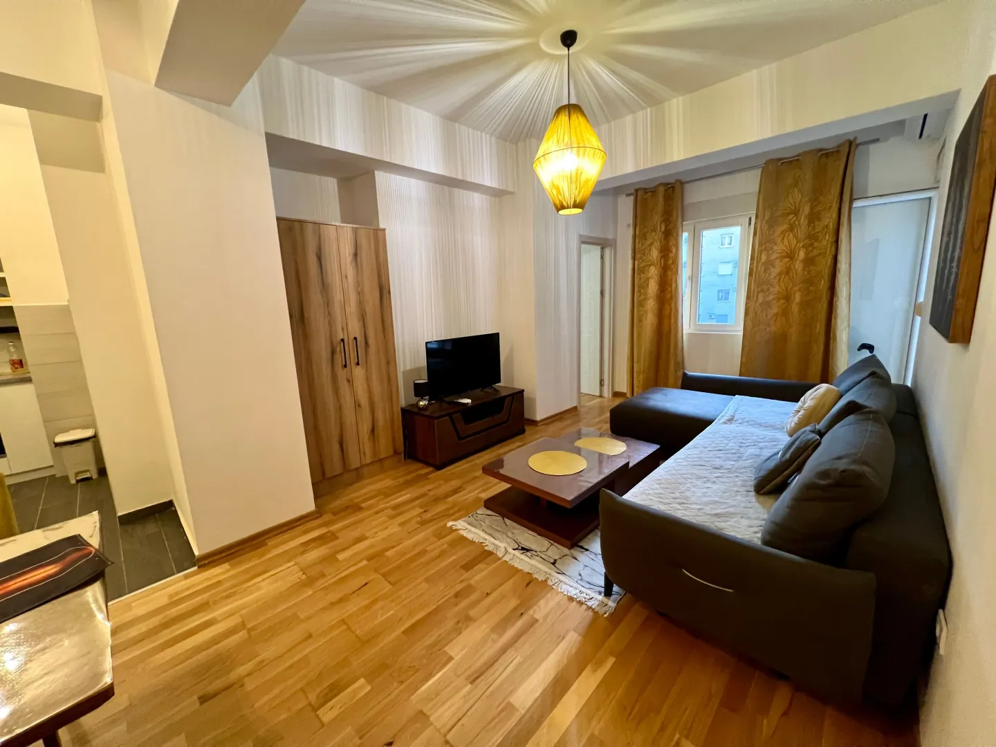 Spacious living room with a sofa set and wooden flooring.