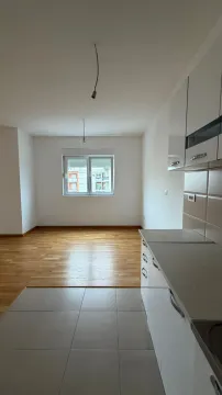 Pogled na kuhinju i trpezarijski dio sa drvenim podom i prozorom. - image 5
