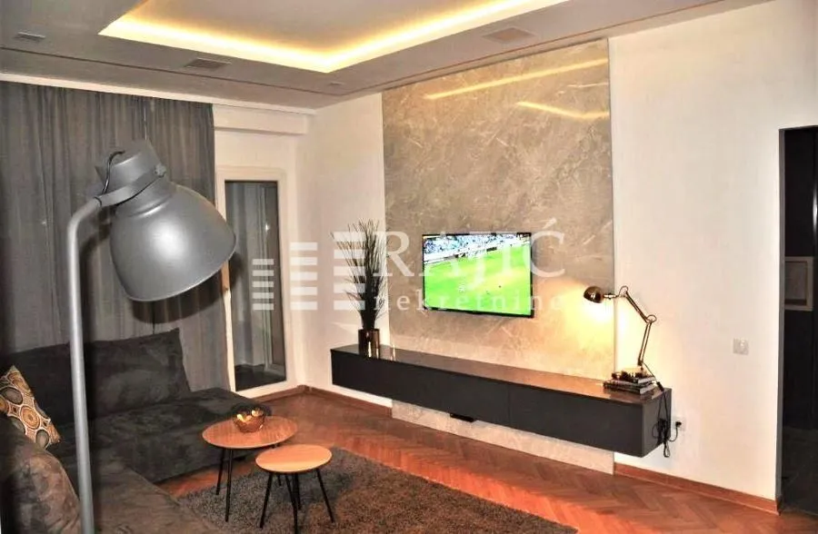 Modern living room with a sofa and wall-mounted television.