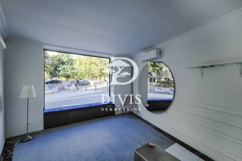 Empty room with a large window and a street view.