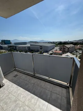Manji popločani balkon sa staklenom ogradom i pogledom na grad. - image 13