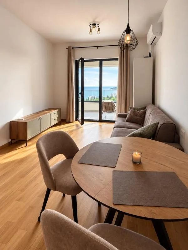 Living room with a dining table and access to a terrace with a sea view.
