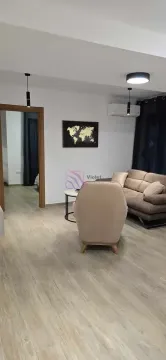 Dnevna soba sa garniturom za sjedenje, foteljom i mapom svijeta na zidu. - image 3