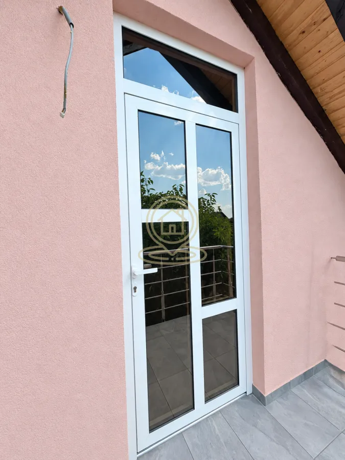 White balcony doors on a pink facade.
