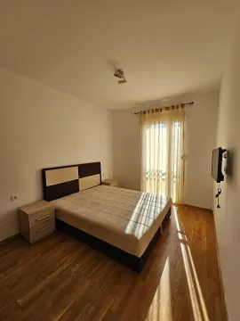 Spavaća soba sa bračnim krevetom, noćnim stočićima i balkonskim vratima. - image 5