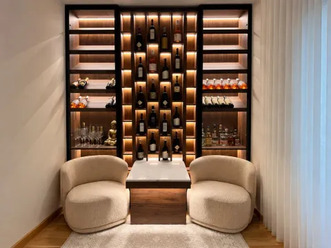 Living room with a large wooden wine display cabinet and two armchairs. - image 10