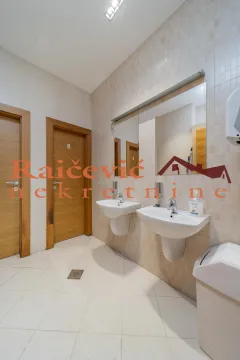 Public bathroom with two sinks, mirrors, and tiled walls. - image 9
