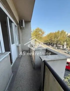 Long balcony with a view of the street and trees. - image 9