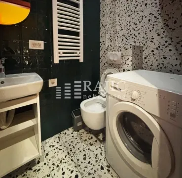 Smaller bathroom with a washbasin, toilet, and washing machine. - image 11