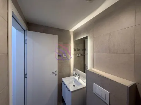 Modern bathroom with a washbasin, backlit mirror, and a concealed cistern. - image 4