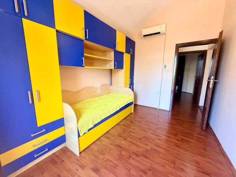 Children's bedroom with a blue and yellow wardrobe and bed.