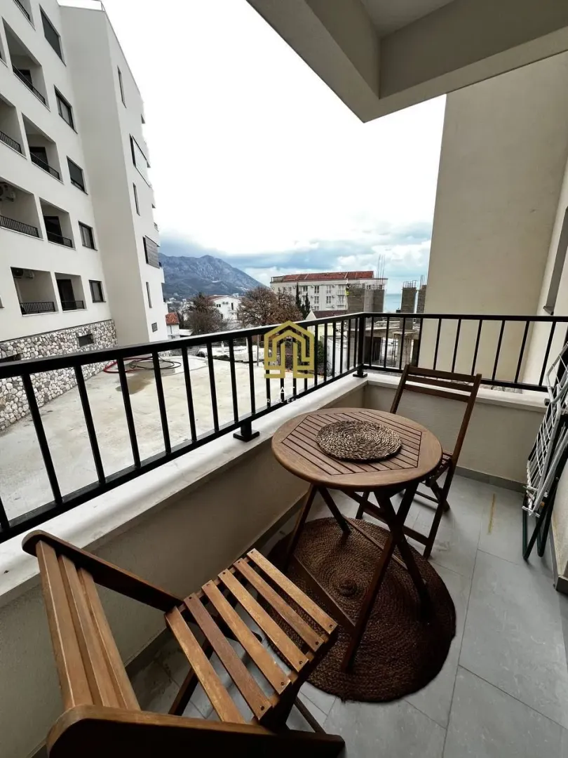 Manji namješteni balkon sa stolom i dve stolice.
