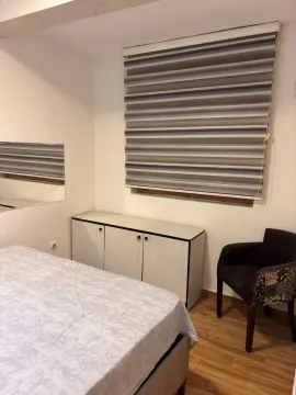 Smaller bedroom with a bed, dresser, and armchair. - image 6