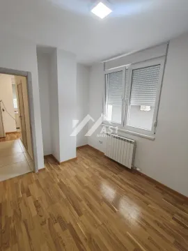 Prazna soba sa parketom, belim zidovima i prozorom sa roletnama. - image 12