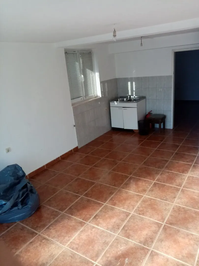 Empty room with a kitchen sink unit and tiled floor.