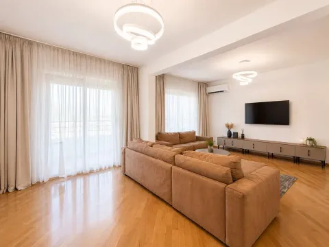 Spacious and bright living room with a sofa set and TV. - image 2