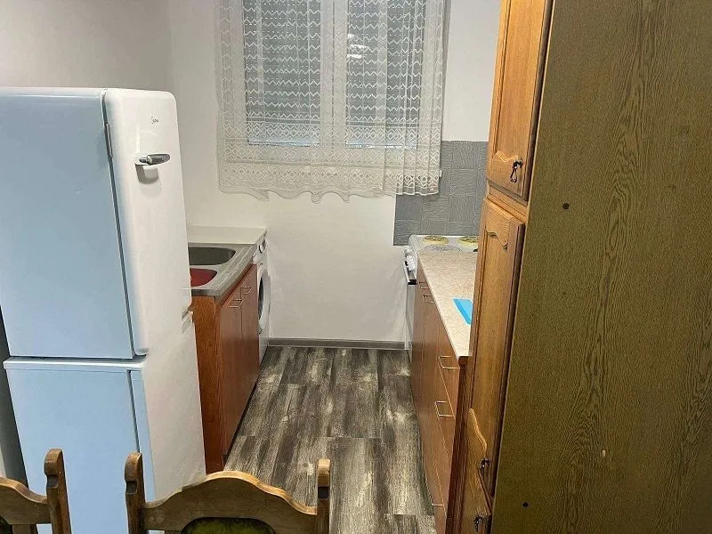 Smaller kitchen with wooden units and white goods.