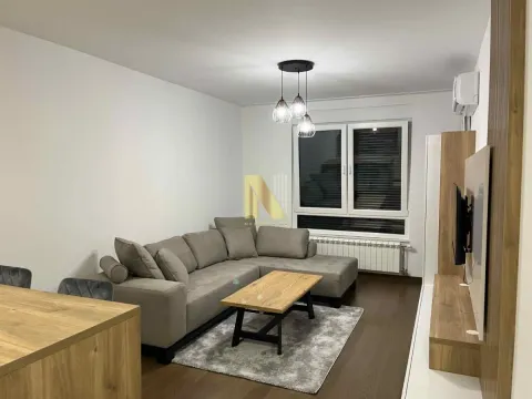 Dnevna soba sa ugaonom garniturom, stočićem i televizorom na zidu. - image 2