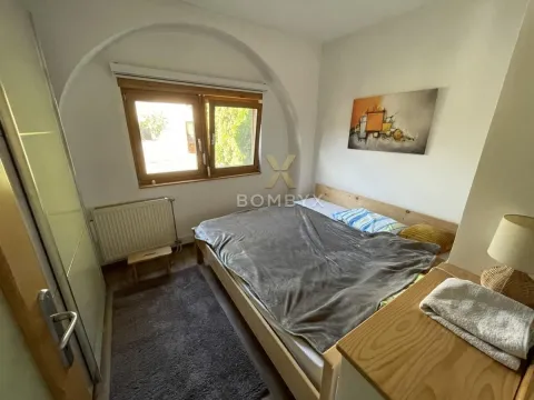 Nameštena spavaća soba sa bračnim krevetom, prozorom i radijatorom. - image 31