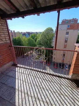 Natkriveni balkon sa pogledom na ulicu i zelene površine. - image 6