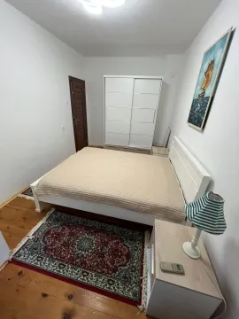 Bedroom with a double bed, white wardrobe, and wooden flooring. - image 3