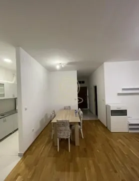 Trpezarija sa drvenim stolom i stolicama, povezana sa kuhinjom i hodnikom. - image 3