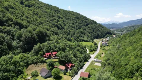 Pogled iz vazduha na kuće okružene šumom i prirodom. - image 7