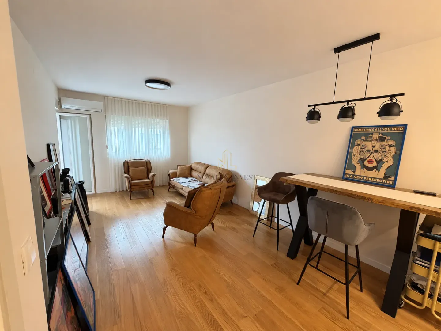 Dnevna soba sa garniturom, foteljama i šankom za ručavanje.